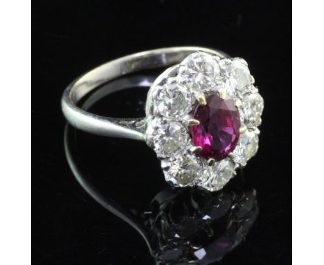 An 18ct white gold, ruby and diamond cluster ring, of oval form, with an estimated total diamond weight of 1.50-1.60ct, size 