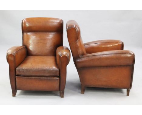 A pair of 1940's French brown leather upholstered club armchairs