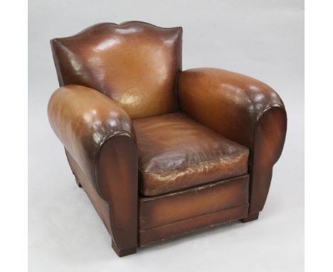 A 1930's brown leather upholstered armchair, with shaped back and rounded arms