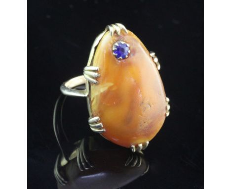 A gold, amber and sapphire set dress ring, the pear shape amber with inset round cut sapphire, size F.