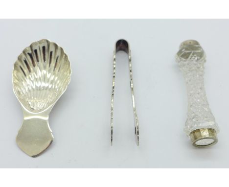 A silver caddy spoon, a pair of silver sugar bows and a knife rest 