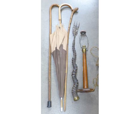 Two canes, one with carved dog's head, an oak table lamp base, an antler handled toasting fork and an umbrella 