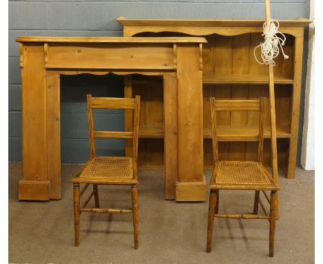 A selection of items to include: a pine fire surround, 127cm high, 144cm across; a pine dresser top; a pair of reeded chairs 