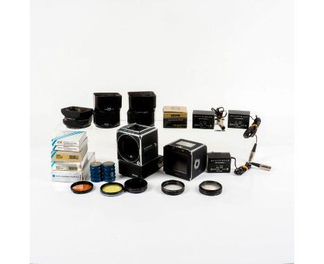 Vintage electric modified camera with assortment of accessories; filters, lens hoods, batteries and more.Hasselblad 500 EL/M:
