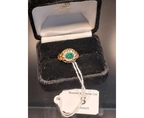A Sheffield 9ct yellow gold ring set with a single green spinel surrounded by white spinel stones. [Ring size K 1/2] [3.36Gra