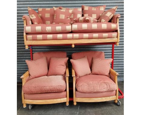 An Ercol Two seat sofa together with two matching single chairs. Light wood frame. 