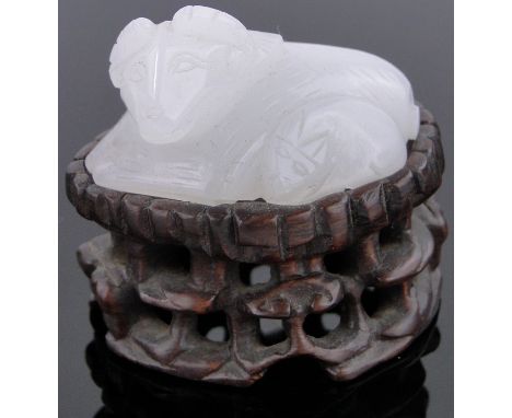 A Chinese carved white jade ram,length 1.75", carved hardwood stand.