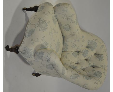 A Victorian button back upholstered armchair,carved fluted legs.