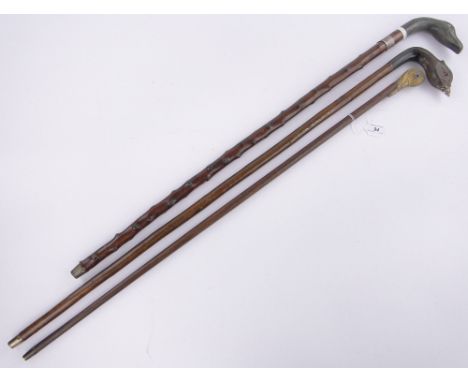 A Victorian walking stick with gilt metal bird's head handle,and 2 other carved horn handled bird's head design walking stick
