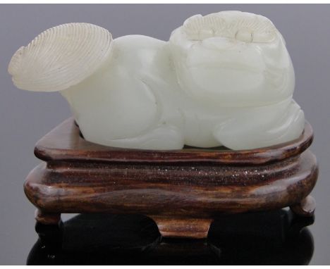 A Chinese carved white jade dragon,carved hardwood stand, length 2".