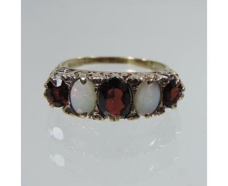 An 18 carat gold opal, garnet and diamond ring, boxed