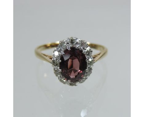 An 18 carat gold ruby and diamond cluster ring, boxed