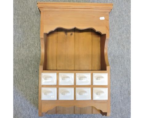 A pine wall hanging shelf, containing ceramic drawers, 42cm