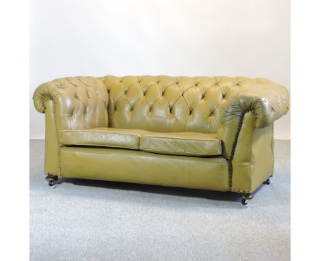An early 20th century green leather button back chesterfield sofa, on bun feet and castors, 175cm