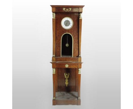 A 19th century Empire style mahogany and gilt metal mounted longcase clock, the glazed case flanked by columns, the white ena