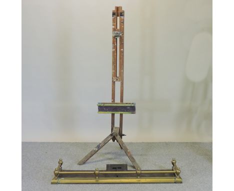 A wooden artist's easel, approx 180cm high, together with a brass fender and a brass top folding table (3)