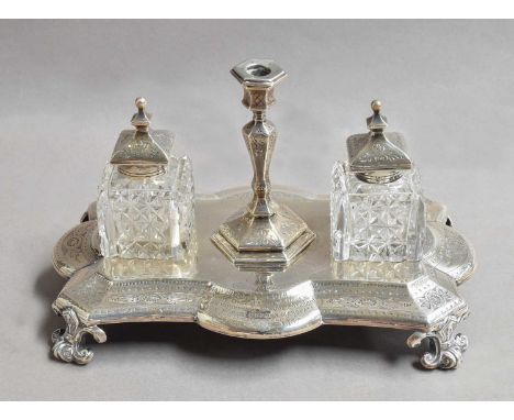 A Victorian Silver Inkstand, by Walter and John Barnard, London, 1877, oblong and on four scroll feet, the shaped base engrav