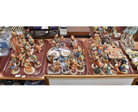 A Collection of Approximately Forty Hummel Goebel Figures, including a larger figure of an angel with two children at her fee