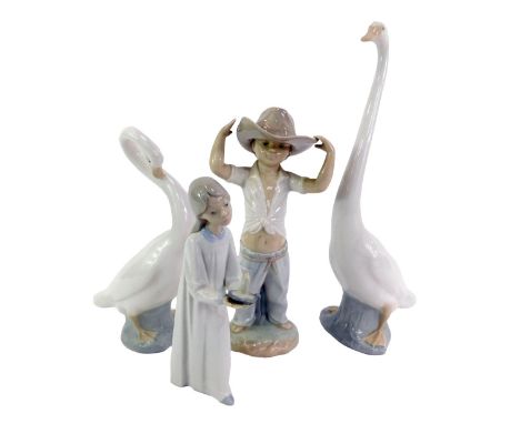 A group of Nao, comprising two geese, 34cm high and 25cm high, figure of a young boy wearing hat, 26cm high, and a Lladro por