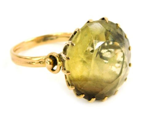 A citrine dress ring, the circular stone in a raised claw basket setting, on a yellow metal band, unmarked, ring size S, 9g a