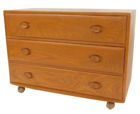 An Ercol elm chest, of three drawers, on castors, model number 412, bearing label, 66cm high, 92cm wide, 43cm deep.