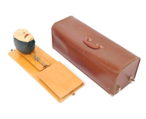 A mid century CPR model, depicting a female face mounted on hardwood board, with outer case, 62cm long.