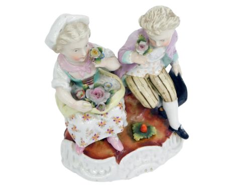 A late 19thC Sitzendorf porcelain figure group, modelled as two seated children with flowers, on an oval rococo scroll base, 