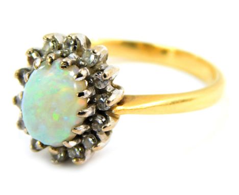 An opal and diamond dress ring, the oval opal in claw setting, approx 0.5ct, surrounded by tiny diamonds, each claw set, on a