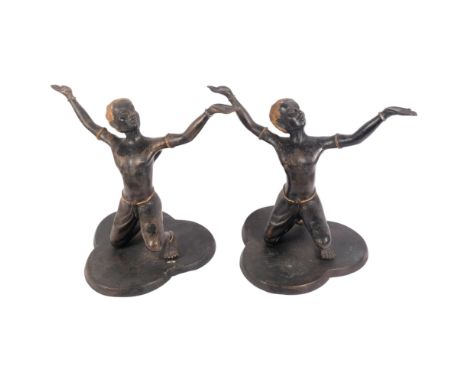 A pair of hollow cast and patinated bronze African kneeling dancing figures, on trefoil bases, H41cm