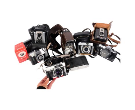 A collection of various cameras, including a Pentax ME Super with 50mm lens, Kodak Instant Load 126 camera, Brownie Hawkeye, 