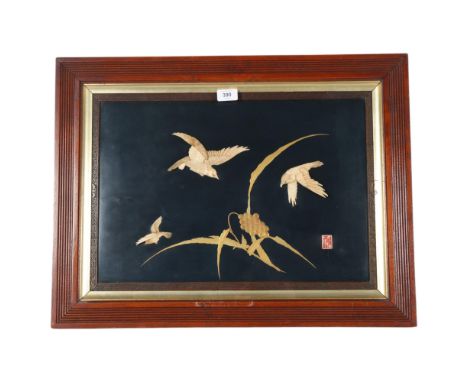 A 19th century Japanese fabric panel, with applied bone carvings of birds, gilded decoration and stamp, in flued mahogany fra