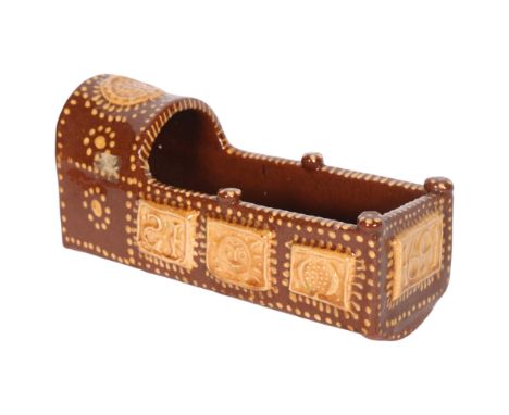 A slipware model cradle, decorated in cream slip on dark brown ground, with initials IH and date 1691, 23cm, cradles of this 