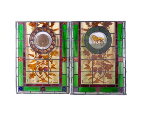 A pair of Art Nouveau leadlight and coloured glass panels, a central panel depicting fruit and flowers, each have a central r