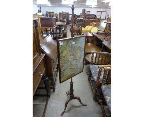 An early 19th Century oak pole screen, with embroidered panel and acorn finial 