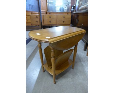 An Ercol style light oak drop leaf magazine rack 