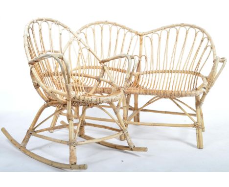 A retro vintage 1960's bamboo wicker cane sofa settee bench and matching rocking chair having a bent cane frame , rounded bac