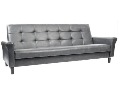 A retro 20th Century black vinyl leather sofa settee having a buttoned square back rest with cushioned arms and buttoned seat