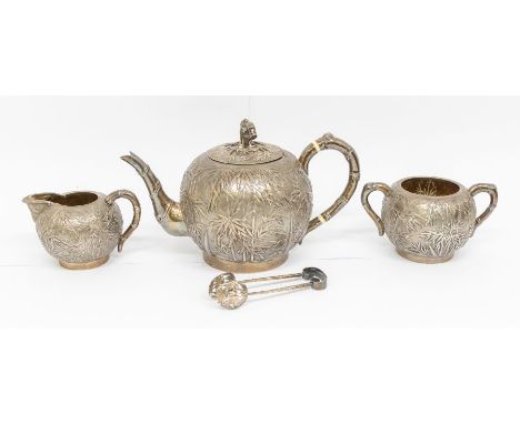 An early 20th Century Chinese Export silver three piece tea service and matching sugar tongs, hallmarked by Wang Hing & Co., 