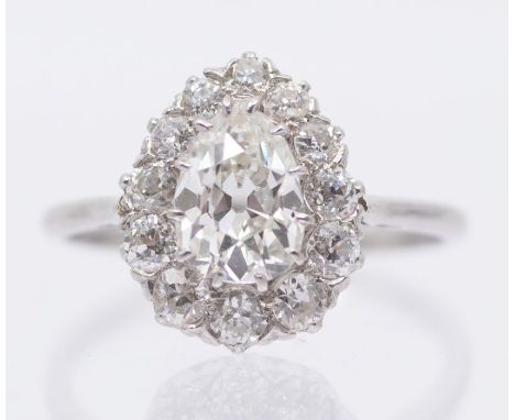 A diamond and platinum cluster ring comprising a pear shaped old cut diamond to the centre weighing approx 1.30carat, assesse