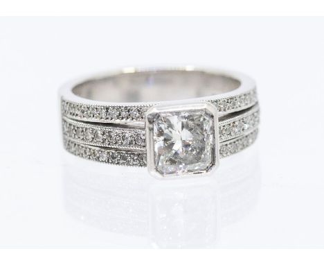 A diamond and platinum dress ring, comprising a central rub over set radiant cut diamond weighing approx. 1.05carats, assesse