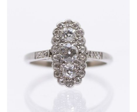 An Edwardian diamond and platinum cluster ring, comprising an elongated lozenge set to the centre with three graduated old cu