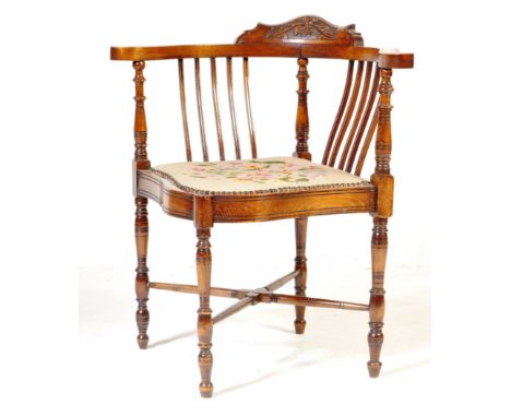 An Edwardian mahogany corner chair. Having a carved crest rail with a pierced gallery back, tapestry seat with polychrome dec