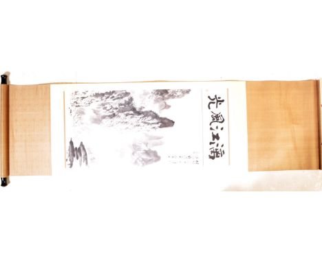 A vintage 20th century Chinese ink scroll having an ink calligraphic script featuring a mountainous landscape with fishing bo
