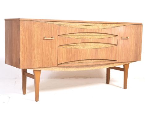 A retro vintage mid 20th century Formica sideboard having a central bank of drawers flanked by single door cupboards with bra