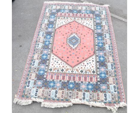 A vintage 20th century Moroccan rug having a pink outer border decorated with geometric patterns surrounding a cream panel wi