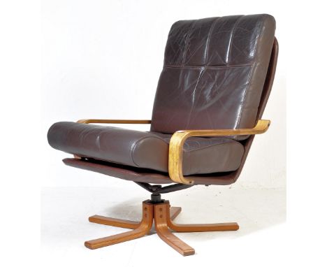 A retro vintage 20th century brown leather swivel armchair / easy chair / office chair having a show wood elbow rests raised 