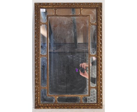 A 20th century Venetian style wall mirror having a central mirror glass panel surrounded by smaller panels within a carved fo