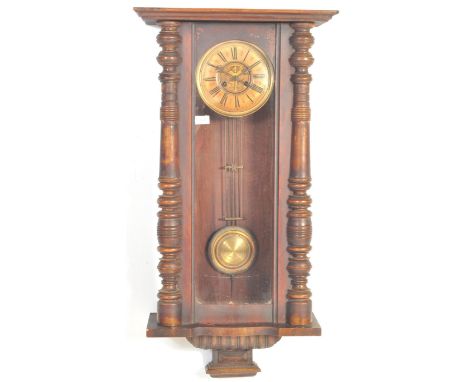 A 19th century Victorian Vienna regulator wall clock having a stepped flared cornice over a glazed case flanked by two pilast