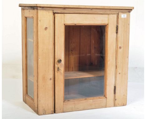 A Victorian 19th century country pine glazed hanging display cabinet. The pine body with central door having unglazed centre 