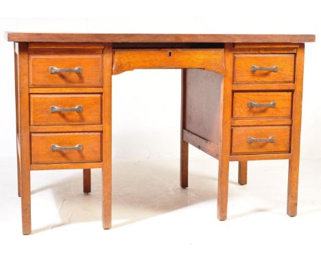 A retro vintage mid 20th century circa 1950s oak pedestal desk having a central kneehole flanked by banks of drawers raised o